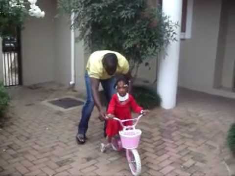 Free State Stars Captain, Kennedy Mweene teaches his daugher to ride a bicycle.