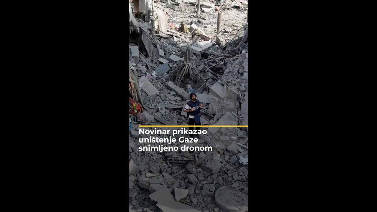 صحفي يعرض صوراً لدمار غزة التقطتها طائرة مسيرة.