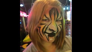 facepainting a beautiful girl into a Rainbow Tiger at a party!