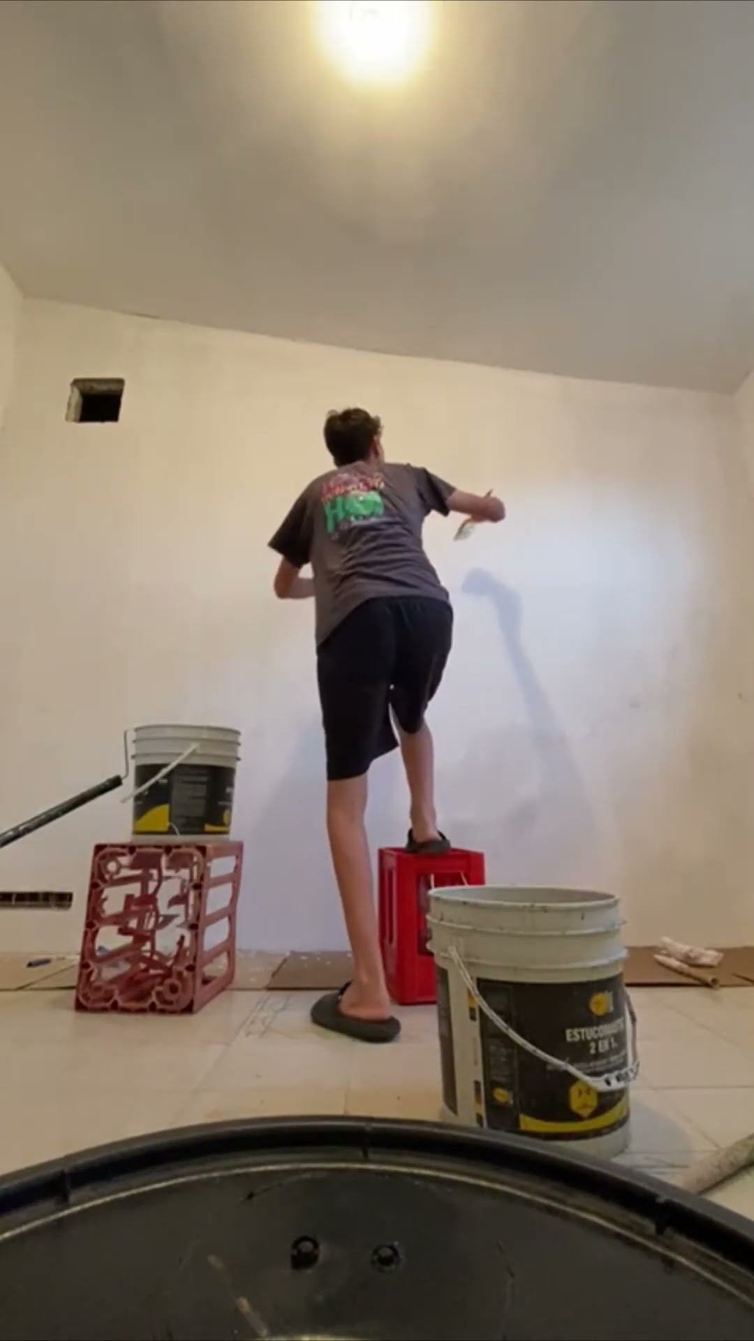 Man Loses Balance and Falls Off Crate While Painting a Wall