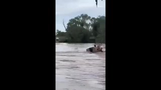 Momen mengerikan ketika dua pria ters engulfed oleh air banjir di Queensland.
