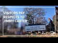 Visitors pay their respects to Jimmy Carter as the former present lies in repose at The Carter Cente