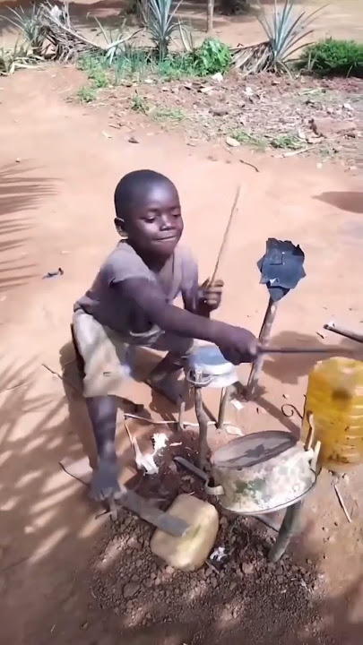 Anak laki-laki kecil memainkan drum buatannya sendiri.