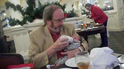 Dad is holding and feeding Anthony at the christma...