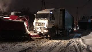 Грузовой эвакуатор Mercedes 8х4 затаскивает фуру в заснеженный подъем.