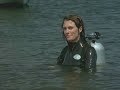 A Female diver in a rubber wetsuit (and a male diver "trapped" underwater)