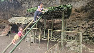 Girl building a thatched roof for a bamboo house - single mother