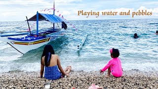 Baby And Mom Play At The Beach Get Water For Pebbles