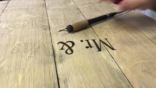 Wood burning a whiskey barrel head.