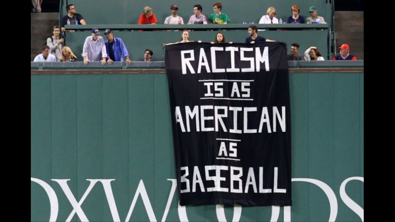 Protesters hang banner at Fenway Park that says 'Racism is as American as baseball' games people play