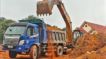 CAT excavator scoops soil onto truck TMT