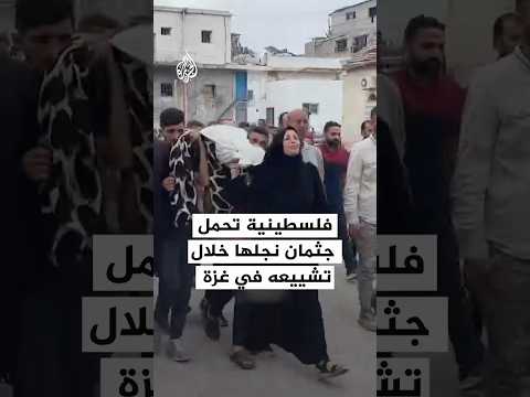 فلسطينية تحمل جثمان نجلها خلال تشييعه في غزة
