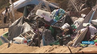 Trash and a homeless camp polluting a popular surf spot