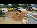 Perfect opening new project showing mighty bulldozer komatsu working push stone fill into the water