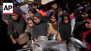 Palestinians wait to receive food at a community kitchen in Gaza
