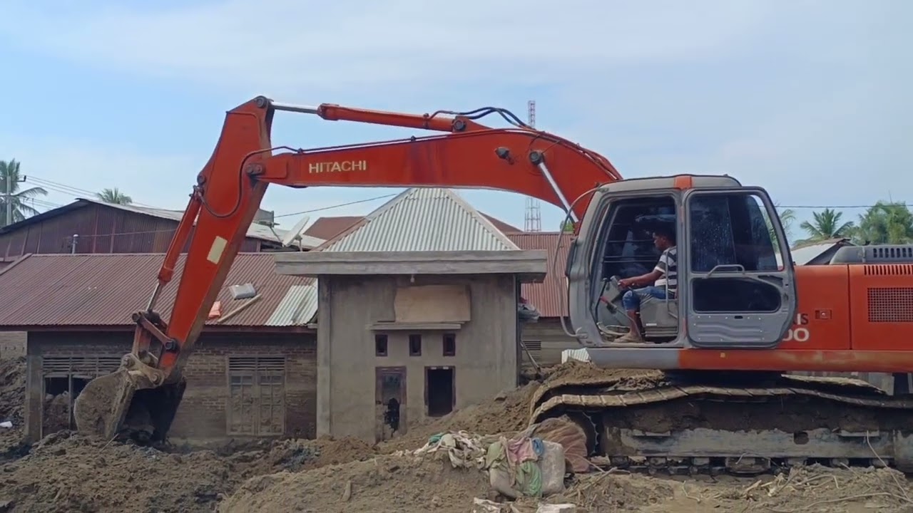 a hitachi excavator is clearing a buried house