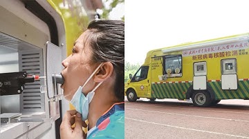 Vehicle with robotic arm conducts COVID-19 tests in central China