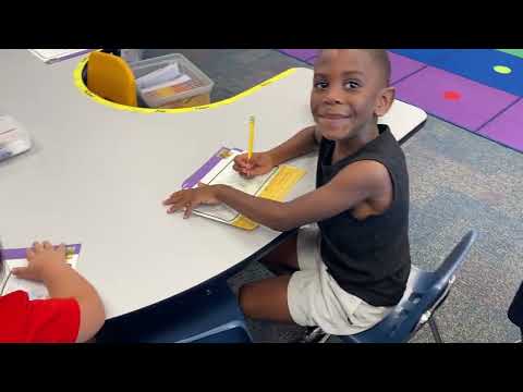 Kinders adding details to their reading assignments.