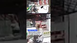 Motorcyclist crashes through moving bus