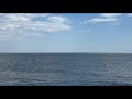 Waves crash beneath blue skies at Two Lights State Park