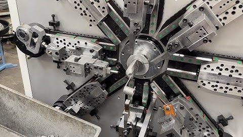 CNC wire-forming and coiling machine coiling a torsion spring