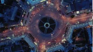 Aerial view of traffic at the intersection of a circle. The drone descends to the intersection