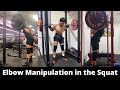 Manipulating the elbows to achieve a flat back in squats