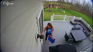 Boy jumps off swing when its at its peak and lands on stomach on grass in backyard (Security camera)