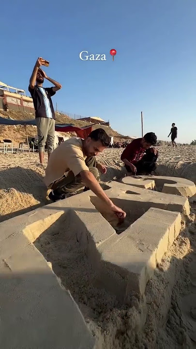 Palestinian artists in Gaza use the beach sand to write 'Save Gaza' #gaza #palestine #shorts