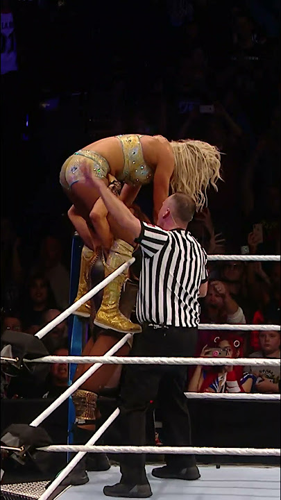Becky Lynch powerbombs Charlotte Flair through the table!