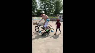 BMX rider goes up ramp at skatepark and crashes into two little kids on bike and scooter