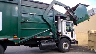 Garbage truck emptying a dumpster