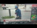 Weatherman dramatically braces for Hurricane Florence while 2 guys casually stroll by