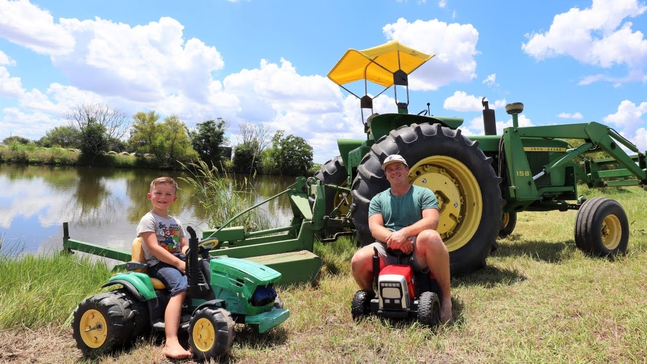 Using real tractors and toy tractors to mow grass and play in mud
