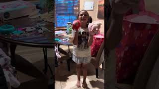Little girl opens a present for her happy birthday. She turned 9 1/2 years old. ￼