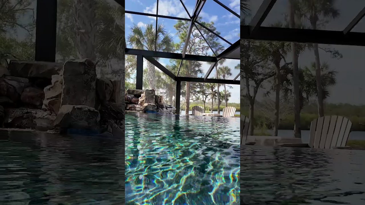 This project features natural rock waterfalls, a beautiful spa, an infinity edge, and a pool cage.