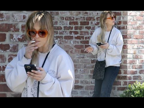 Kaley Cuoco enjoys a smoke break while scrolling through her phone on the  Los Angeles set of the sec