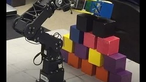 Robot arm stacking blocks in a pyramid