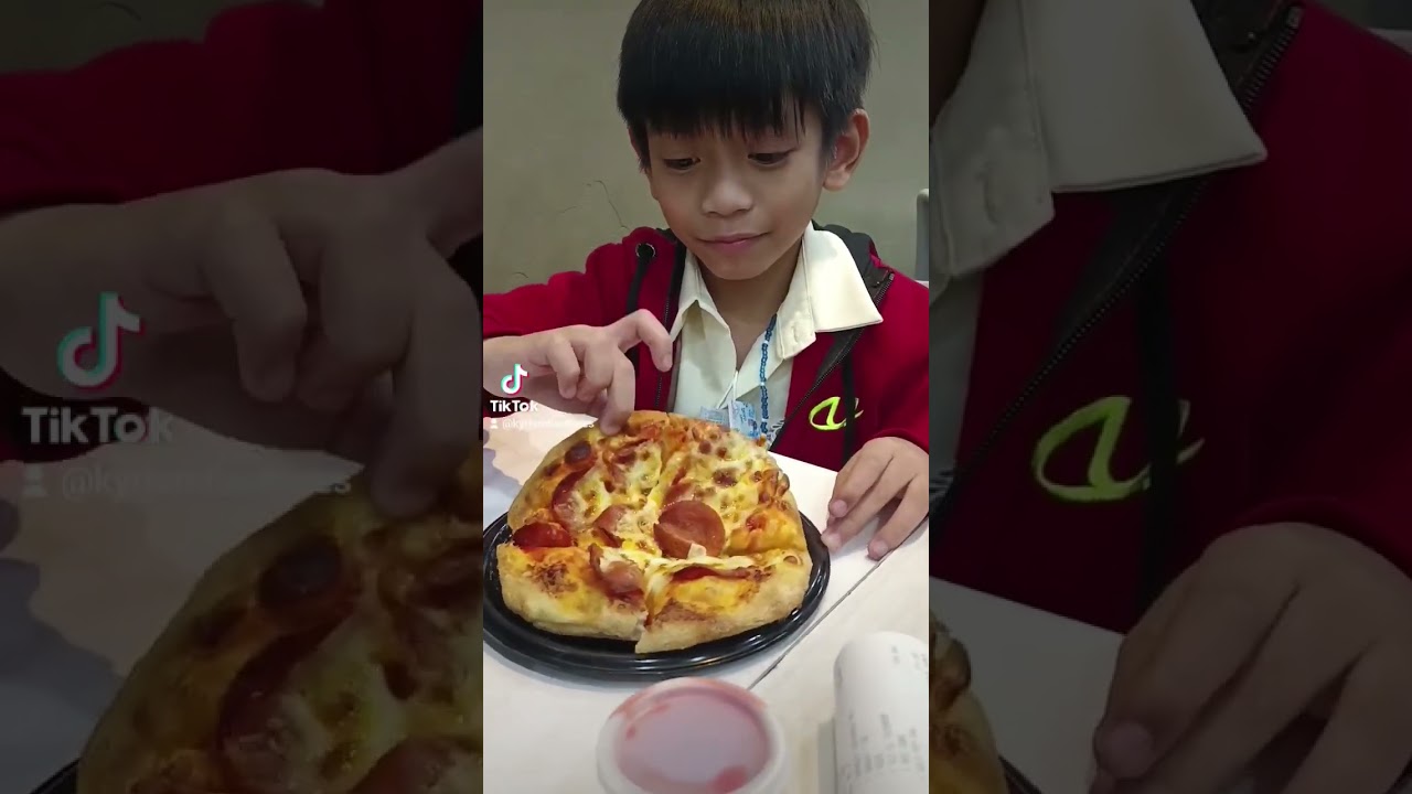 HAPPY KID ENJOY EATING DELICIOUS PEPPERONI PIZZA FROM GREENWICH 