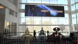 Bruce Gray Welds his Robot Sculptures on the Giant Screen at Westfield Mall