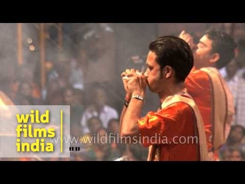 Priests blow conch shell Shankh before Ganga aarti at Banaras