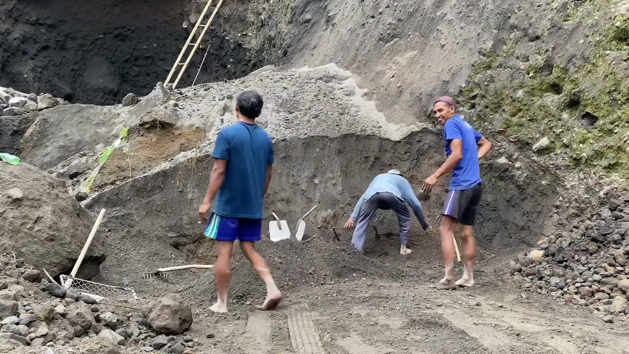 Manual sand miners collect sand to be loaded onto trucks.