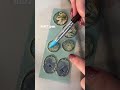 Person shows the process of creating botanical-resin jewelry pendants!