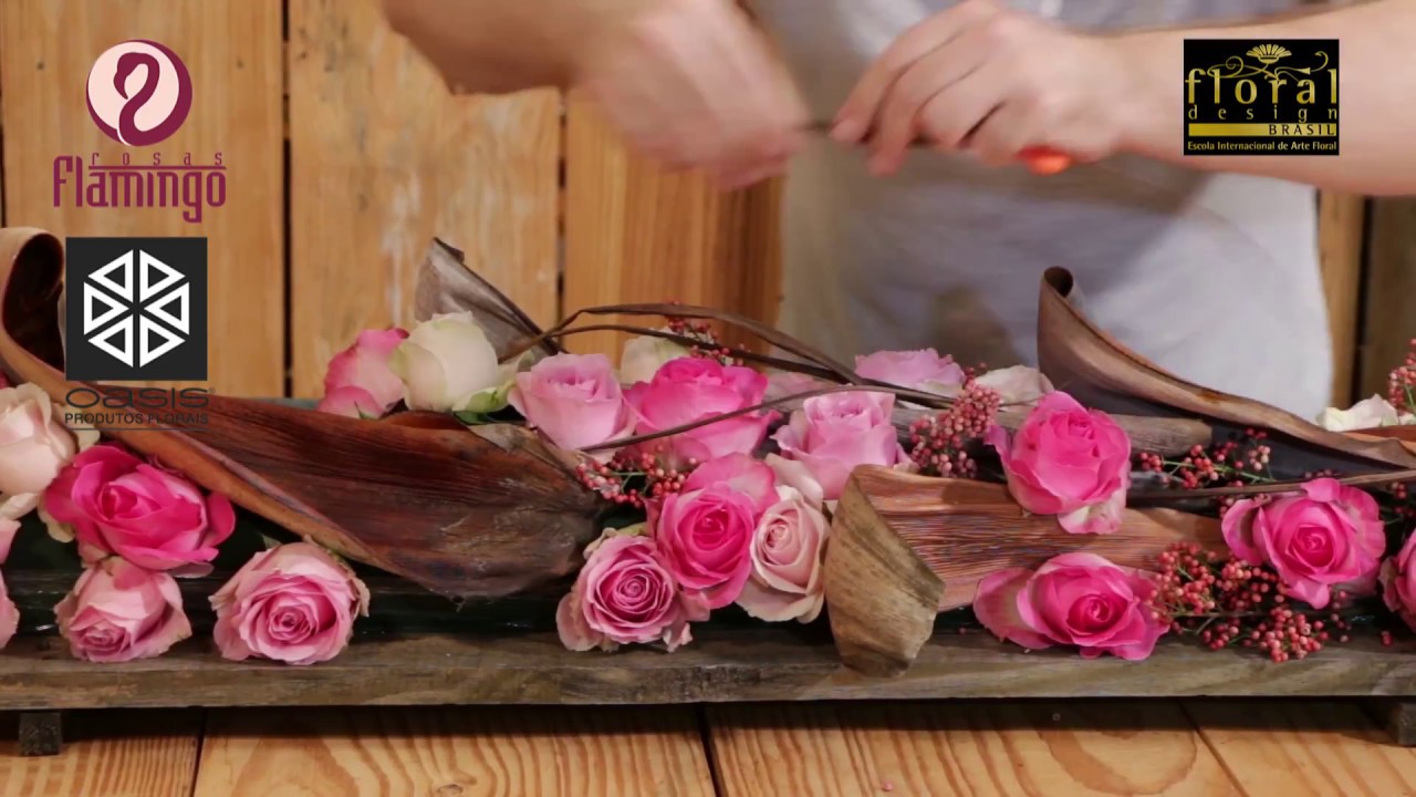 Arranjo de flores com rosas e cascas de palmeira para uma decoração rústica