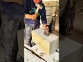 Worker chisels stone carefully showing precise masonry method