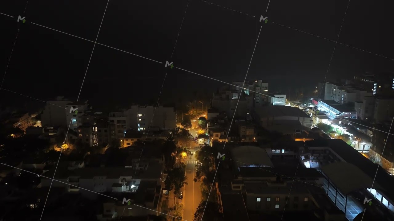Aerial view of illuminated streets and buildings in Miraflores, Lima, Peru, with the dark Pacific