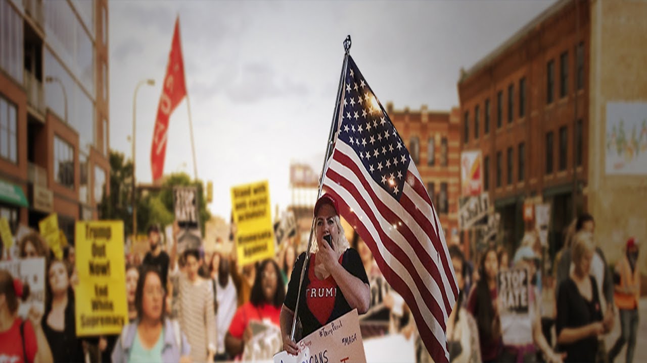 A photo of a protest in Charlottesville, with a sea of people holding signs and chanting slogans