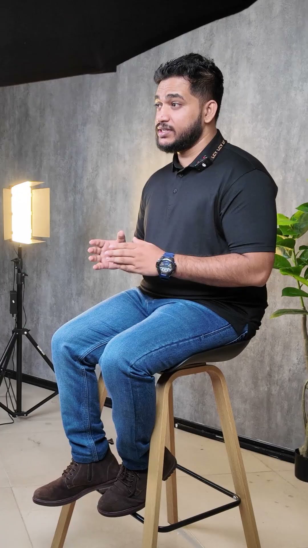Seated presenter beside a studio light