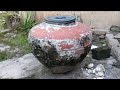 Large Weathered Clay Water Jar Resting Inside Rustic Backyard Area