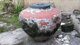 Large Weathered Clay Water Jar Resting Inside Rustic Backyard Area